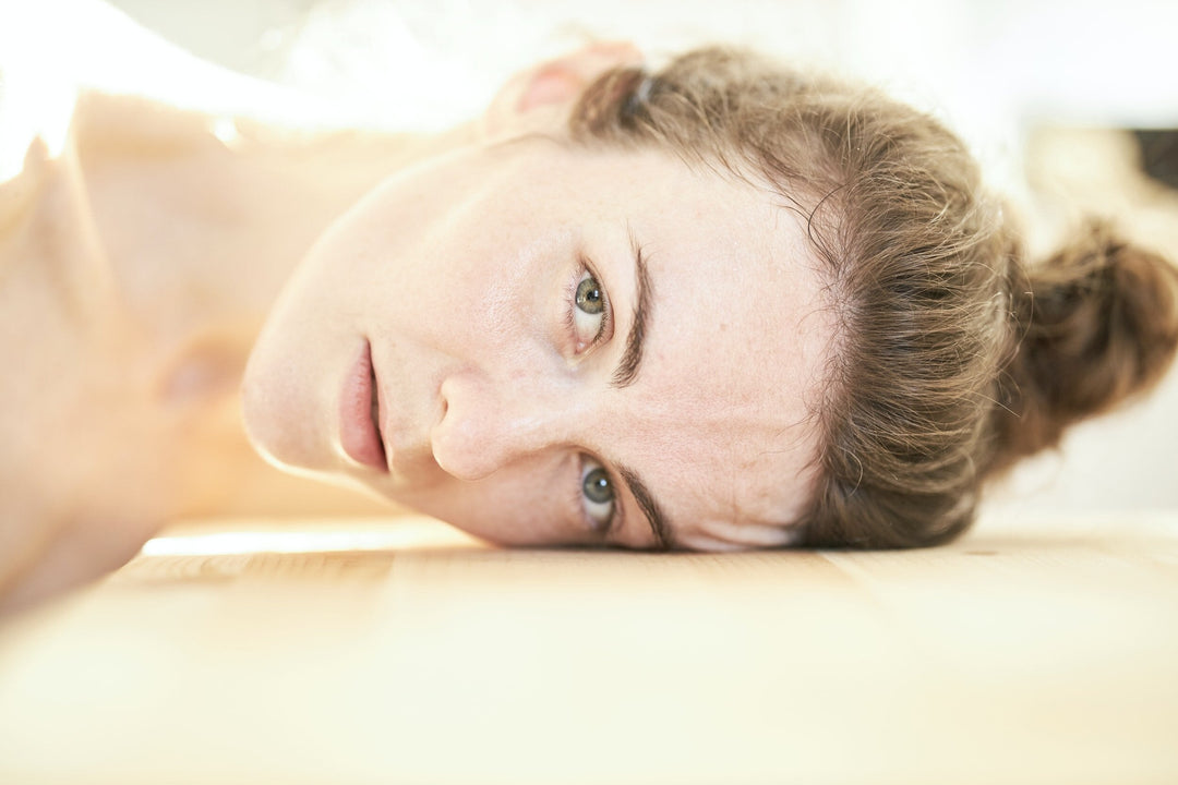 A young woman laying her head down on a surface